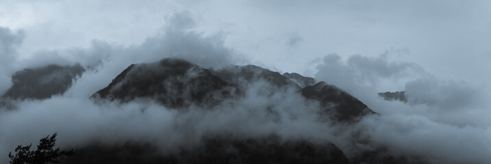 Dark Misty Clouds Engulf Towering Mountain Peaks Creating a Dramatic and Mysterious Atmosphere in Taiwan’s Wilderness