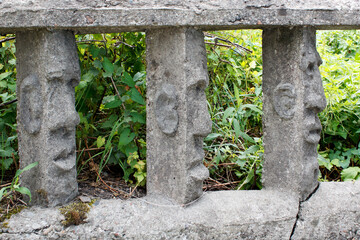 Naklejka premium stone fence with human faces