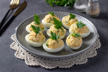 Eggs stuffed with squid and green onions on gray background. Festive snack. Close-up