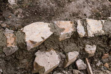 Close up of rock masonry and concrete, builder making edge for path in modern urban garden. Stone pathway in cottage garden.