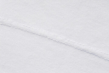 White fine jersey cotton fabric texture with a diagonal seam as background