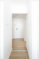 Narrow hallway in a small apartment in a building, with walls being freshly painted, highlighting a cozy and refreshed interior