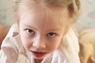 portrait of a little girl came to the camera and looking straight into it. 