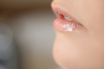 Obraz premium close up of a young woman applying lip gloss