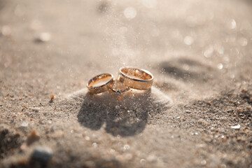 Summer wedding rings on the beach on the sand wind 