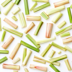 Flat lay of chopped lemongrass stalks on white background.