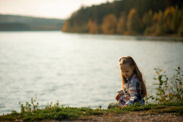 portrait of a five year old girl standing near a lake