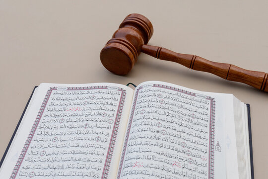 Perspective View of Wooden Gavel and Open Holy Quran Symbolizing Sharia Law and Justice