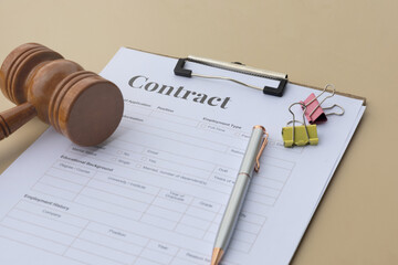 A well-organized legal contract document resting in a clipboard, complemented by a judge’s hammer...