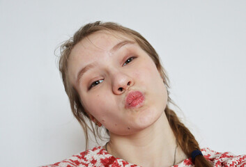 portrait of a girl with a funny face. young woman pursed her lips into a bow. close up face.