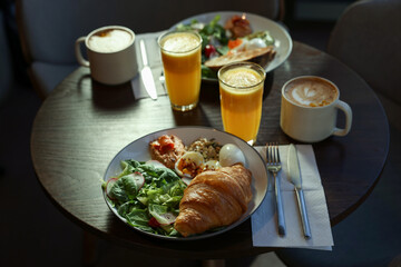 Tasty breakfast. Different meals and drinks served on wooden table in cafe, closeup