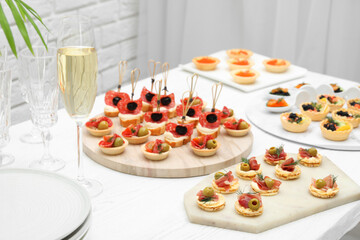 Many different tasty canapes on white wooden table