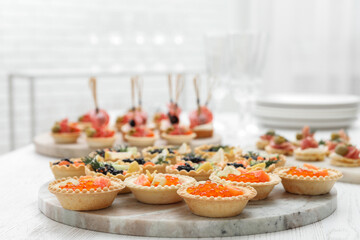 Many different tasty canapes on white wooden table, closeup