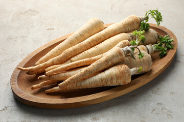 Many fresh parsley roots on grey table, closeup