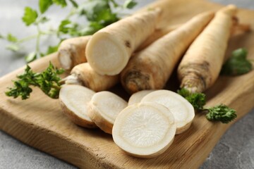 Parsley roots and leaves on grey table, closeup
