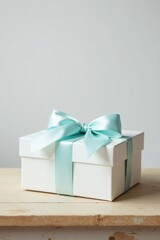A pristine white gift box adorned with a delicate light blue ribbon, signifying a thoughtful present, rests elegantly on a rustic wooden surface.