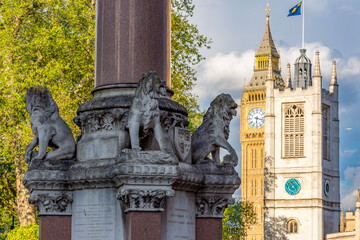 Lion sculptures of Scholars War Memorial at Westminster Abbey, St. Margaret church and Big Ben,...