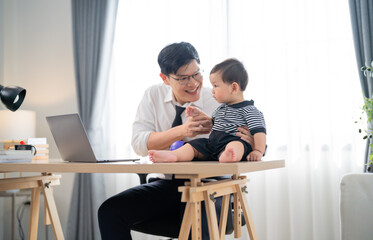 Father enjoys playful moment with toddler at home office during morning hours