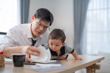 Father engaging with child while working at home office in bright room