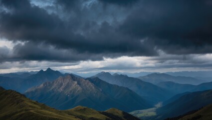 Mountain landscape under dramatic cloudy sky with multiple mountain ranges and lush green valleys in foreground.