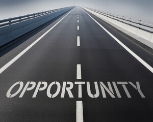 A long, empty highway with the word "OPPORTUNITY" painted on the road, symbolizing a clear path ahead and the potential for success, growth, and new beginnings.