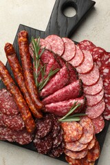 Different smoked sausages slices served on light table, top view