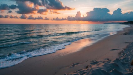 Fototapeta premium sunset over beach with gentle waves and clouds reflecting orange and blue hues in the sky coastal landscape tranquil seascape