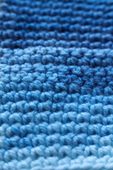 Closeup detail of crochet fabric texture background. Blue color