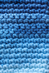 Closeup detail of crochet fabric texture background. Blue color