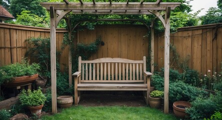 Wooden bench under trellis in private garden surrounded by lush foliage and potted plants against wooden fence