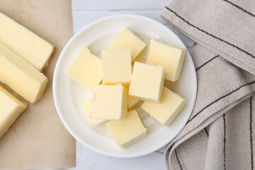 Pieces of fresh butter on white textured table, top view