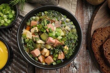 Delicious okroshka soup with kvass and ingredients on wooden table, flat lay