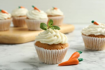 Delicious carrot cupcake with mint on white marble table, closeup