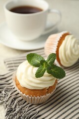 Delicious carrot cupcake with mint on light table, closeup