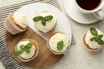 Delicious carrot cupcakes with mint and coffee on light textured table, flat lay