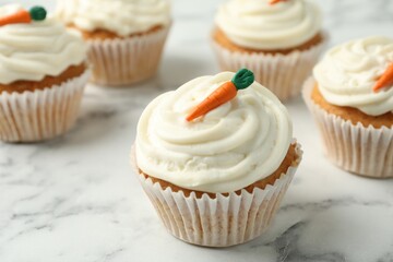 Delicious carrot cupcakes on white marble table, closeup