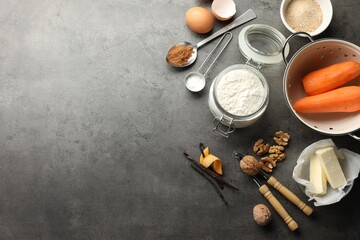 Different ingredients for making carrot cake and kitchenware on dark textured table, flat lay. Space for text