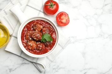 Delicious meatballs with tomato sauce, parmesan cheese and parsley served on white marble table, top view. Space for text