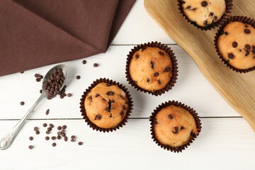 Delicious muffin with chocolate chips on white wooden table, flat lay