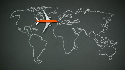 Chalk outline of a world map with a toy airplane