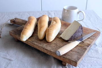 Breakfast with milk, fresh crusty rolls, and cheese.Side view. Concept of food.