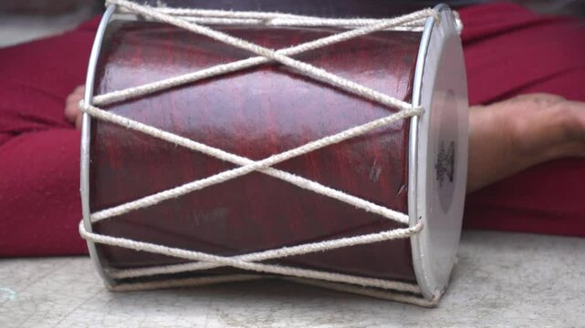 The dholak is a barrel-shaped, two‑headed South Asian hand‑drum, offering bass and treble tones, used in folk, devotional music