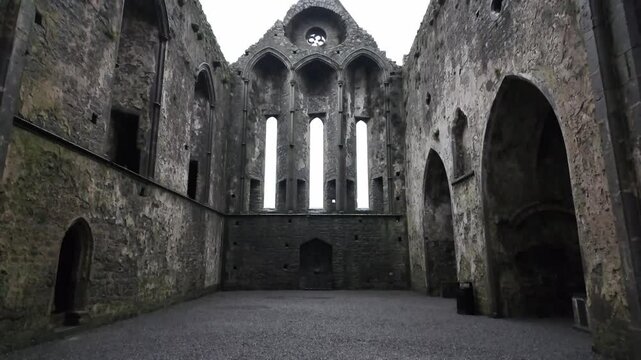A view of the ancient ruins of the Rock of Cashel cathedral in Ireland in a rainy and dark day