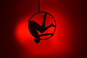 Aerial gymnastics. Gymnast on aerial hoop. Athlete trains on aerial hoop