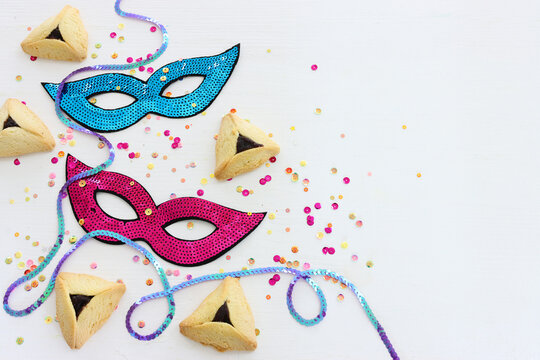 Purim celebration concept (jewish carnival holiday) over white wooden background