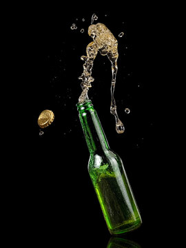 Green beer bottle up and splash on black background, studio shot