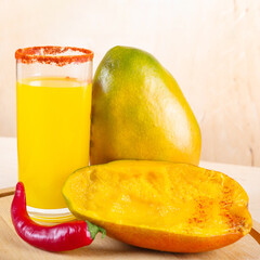 Close-up of mangonada mexican smoothie drink made from mango and chili powder in glass on wooden table
