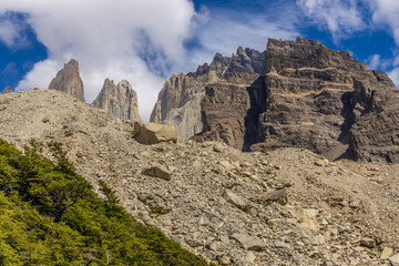 Fototapeta premium Torres del Paine national park mountain landscape in Patagonia, Chile. Los Cuernos and Torres del Paine peak granite towering summits on a nasty and sunny day above the blue water lake in the Andes