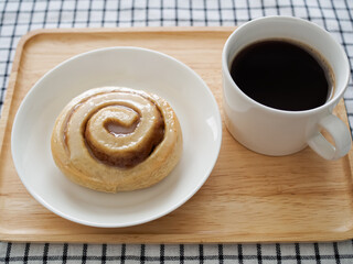 白い皿の上のシナモンロールとホットコーヒー