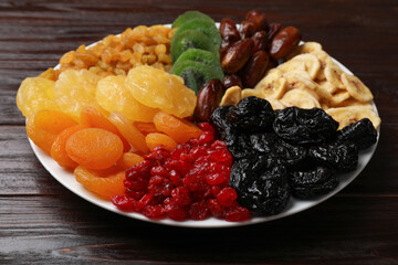 Mix of different dried fruits on wooden table, closeup